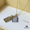 692fd11399f2d84055c89ed9 A pair of name tags engraved with the classic LV Initials signature, featuring contrasting gold and silver finishes, a soft pearl chain, and a buckle adorned with the LV Circle logo.