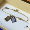 692fd11499f2d84055c89edb A pair of name tags engraved with the classic LV Initials signature, featuring contrasting gold and silver finishes, a soft pearl chain, and a buckle adorned with the LV Circle logo.