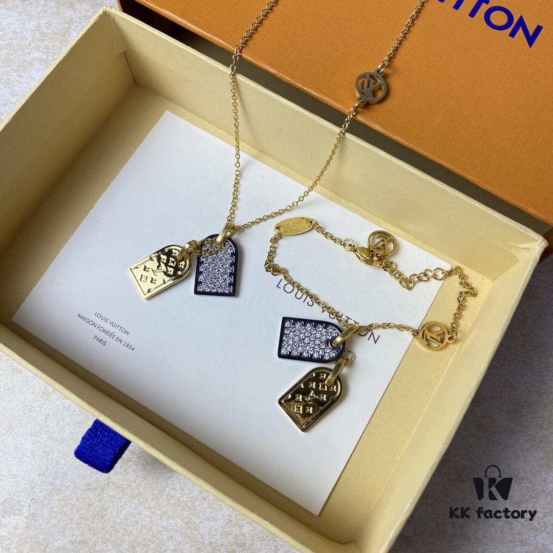 692fd11599f2d84055c89ede A pair of name tags engraved with the classic LV Initials signature, featuring contrasting gold and silver finishes, a soft pearl chain, and a buckle adorned with the LV Circle logo.