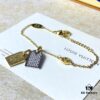 692fd11899f2d84055c89edf A pair of name tags engraved with the classic LV Initials signature, featuring contrasting gold and silver finishes, a soft pearl chain, and a buckle adorned with the LV Circle logo.