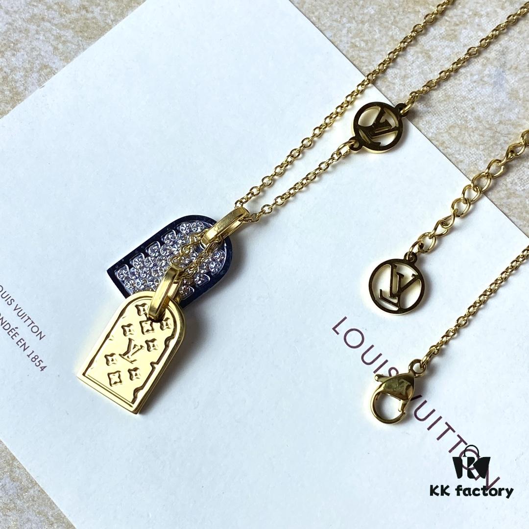 692fd11899f2d84055c89ee5 A pair of name tags engraved with the classic LV Initials signature, featuring contrasting gold and silver finishes, a soft pearl chain, and a buckle adorned with the LV Circle logo.