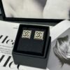 692ffdde99f2d84055c8e987 Xiaoxiang New Arrival Square Smooth Black/White Drip Edge Hollow Double C Stud Earrings (Available in Two Colors)