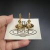 693010ee12f62673a6fac4ba Vivienne Westwood Transparent Glass Orb Earrings in White Gold, Yellow Gold, and Rose Gold