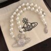 693011b712f62673a6fac5c0 Vivienne Westwood Saturn Pearl Necklace - Medium Size, Rhinestone-Embellished Crown Pendant with Elegant Shine