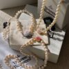 693011c712f62673a6fac5d6 Vivienne Westwood Enamel Pearl Necklace with Magnetic Clasp, Double-Sided Wear, Saturn and Crown Design, Elegant and Edgy Style