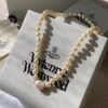 693011c812f62673a6fac5d7 Vivienne Westwood Enamel Pearl Necklace with Magnetic Clasp, Double-Sided Wear, Saturn and Crown Design, Elegant and Edgy Style