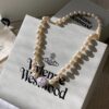 693011cb12f62673a6fac5d9 Vivienne Westwood Enamel Pearl Necklace with Magnetic Clasp, Double-Sided Wear, Saturn and Crown Design, Elegant and Edgy Style