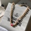 693011cb12f62673a6fac5da Vivienne Westwood Enamel Pearl Necklace with Magnetic Clasp, Double-Sided Wear, Saturn and Crown Design, Elegant and Edgy Style