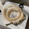 693011cc12f62673a6fac5dc Vivienne Westwood Enamel Pearl Necklace with Magnetic Clasp, Double-Sided Wear, Saturn and Crown Design, Elegant and Edgy Style