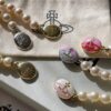 693011ce12f62673a6fac5de Vivienne Westwood Enamel Pearl Necklace with Magnetic Clasp, Double-Sided Wear, Saturn and Crown Design, Elegant and Edgy Style