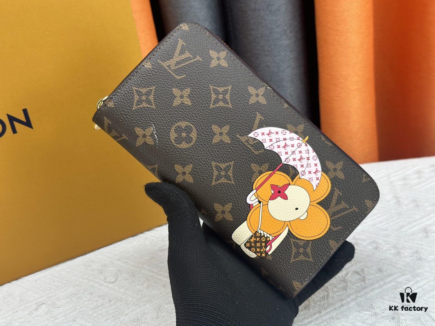 69306fe36e68136f4d9a583d Wallet M60017 Umbrella M80857 M81544 This collectible multicolored zip-around wallet is crafted from Monogram canvas from the Vivienne Holidays 2022 collection, featuring an exquisite print of Louis Vuitton's mascot Vivienne standing in front of the brand's avant-garde Tokyo boutique with Japan's iconic Mount Fuji in the background. This vibrant high-end wallet serves as an invitation to journey and makes a perfect gift.