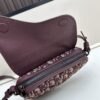 69309d136e68136f4d9ab15f This saddle bag reinterprets the classic design with a modern structure. Crafted from beige and black Oblique printed fabric, it features a signature grained black calfskin magnetic flap and hidden zip closure. The interior includes a spacious compartment and slip pocket for daily essentials. The mini style comes with an adjustable, detachable leather shoulder strap, allowing for handheld, shoulder, or crossbody wear.