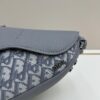 69309d1d6e68136f4d9ab16c This saddle bag reinterprets the classic design with a modern structure. Crafted from beige and black Oblique print fabric, it features a signature black grained calfskin magnetic flap and a concealed zip closure. The interior includes a large compartment and slip pockets for organizing daily essentials. The mini style comes with an adjustable, detachable leather shoulder strap, allowing for handheld, shoulder, or crossbody wear.