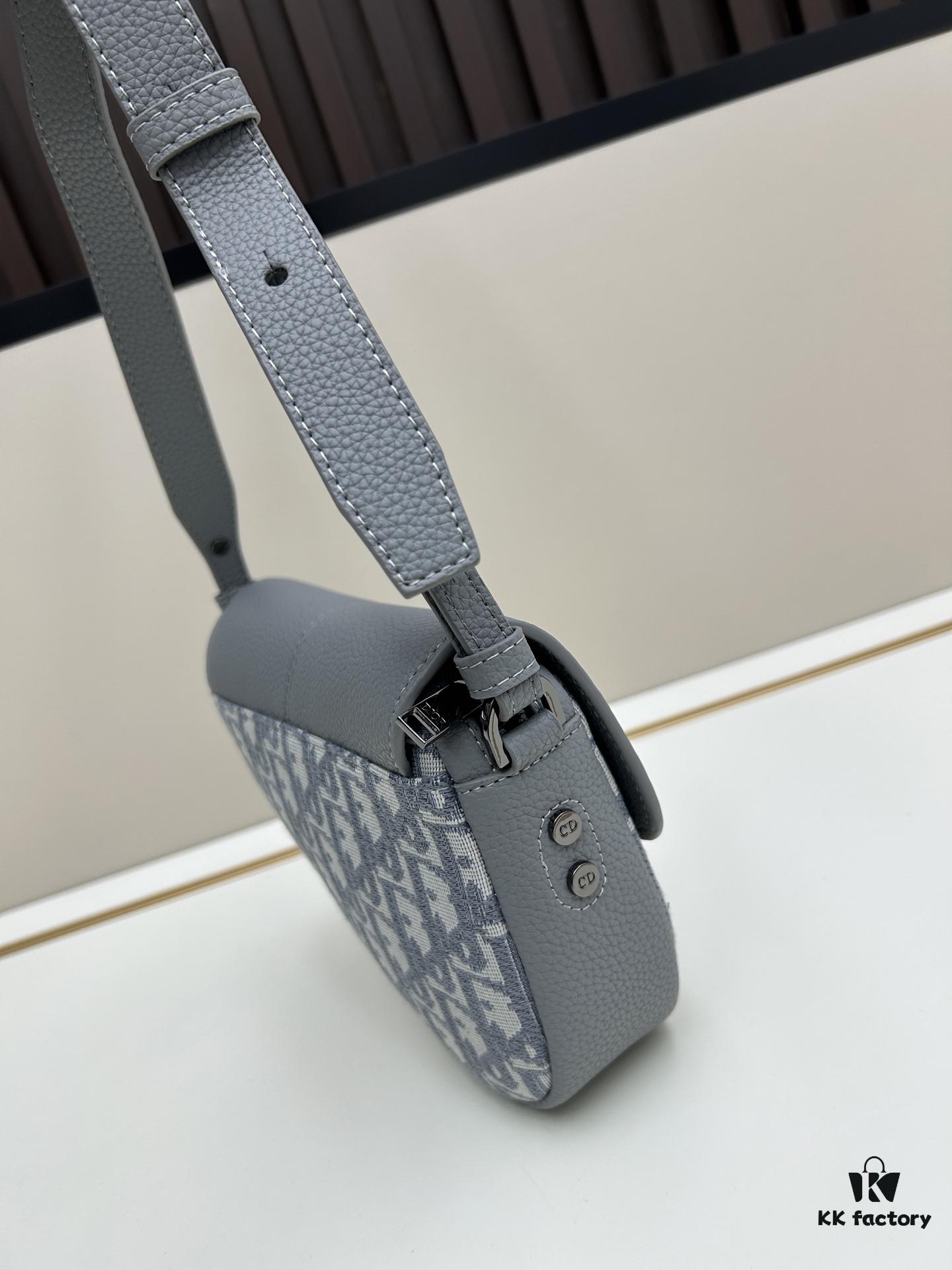 69309d1e6e68136f4d9ab16d This saddle bag reinterprets the classic design with a modern structure. Crafted from beige and black Oblique print fabric, it features a signature black grained calfskin magnetic flap and a concealed zip closure. The interior includes a large compartment and slip pockets for organizing daily essentials. The mini style comes with an adjustable, detachable leather shoulder strap, allowing for handheld, shoulder, or crossbody wear.