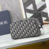6930a71e6e68136f4d9ac470 This toiletry bag combines practical functionality with minimalist design, crafted in beige and black Oblique printed fabric with black grained leather trims, featuring the Dior logo on the front.