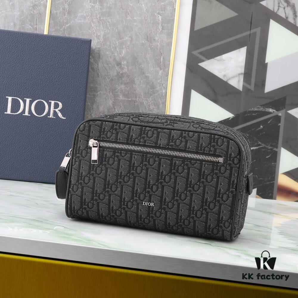 6930a7216e68136f4d9ac477 This toiletry bag combines practical functionality with minimalist design. Crafted from black Oblique-print fabric, it features grained calfskin leather trims in matching tones and is adorned with a Dior signature on the front. The front features a zip pocket, a spacious main zipped compartment, and two slip pockets. Equipped with a leather handle, it can be carried by hand or stored inside various handbags.