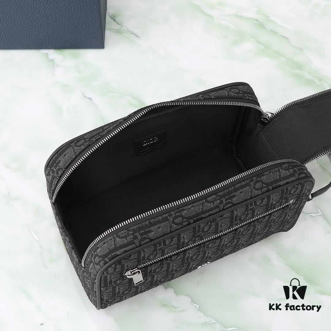 This toiletry bag combines practical functionality with minimalist design. Crafted from black Oblique-print fabric, it features grained calfskin leather trims in matching tones and is adorned with a Dior signature on the front. The front features a zip pocket, a spacious main zipped compartment, and two slip pockets. Equipped with a leather handle, it can be carried by hand or stored inside various handbags.