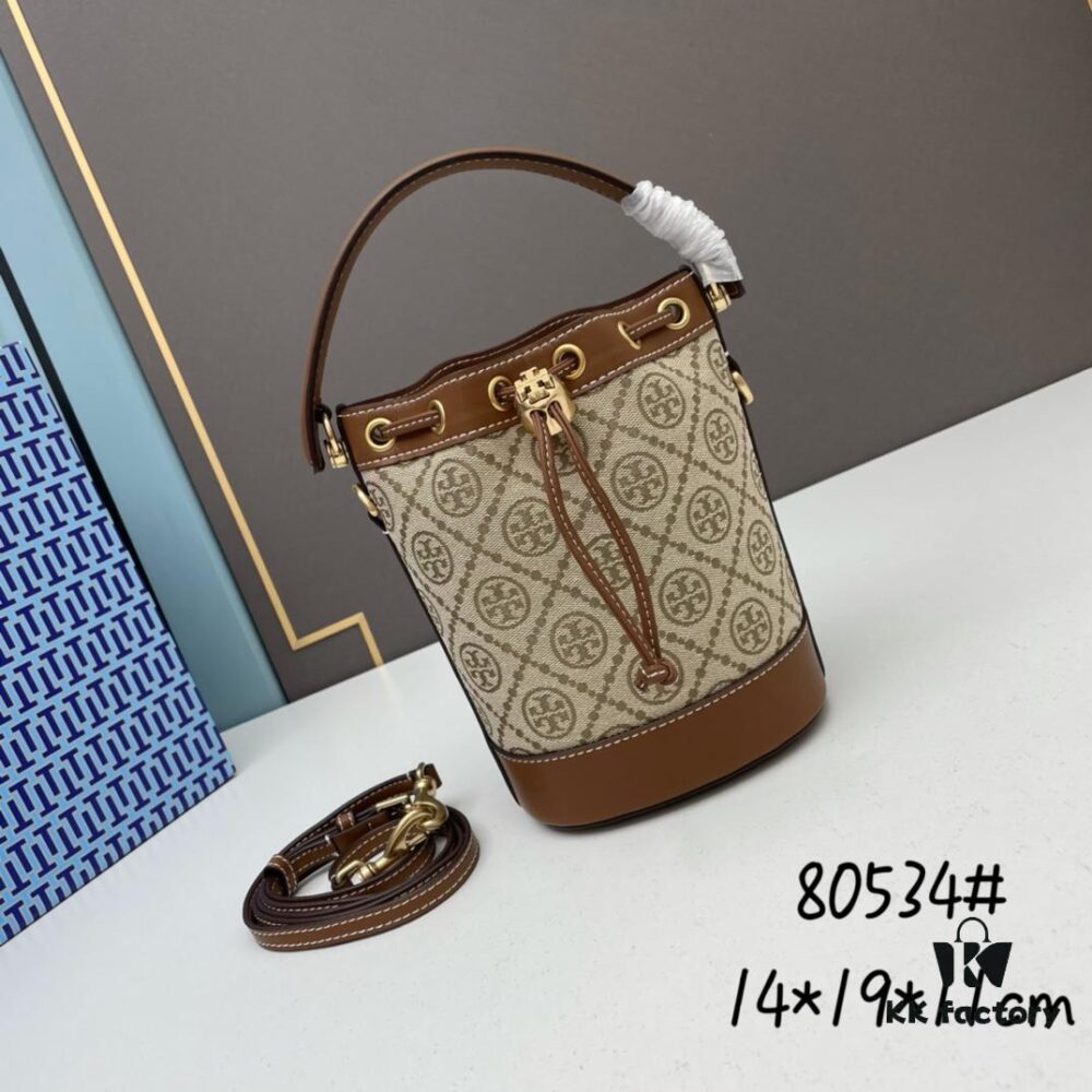 6930afe06e68136f4d9ad501 Hazelnut Color TORY BURCH Monogram 2021 Summer Drawstring Bucket Bag in Textured Navy Canvas with Vintage Jacquard Trim