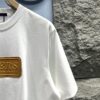 6930fb176e68136f4d9b4645 Louis Vuitton Short Sleeve T-Shirt with Leather Patch Signature Detail