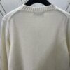 6931a059ccd8ab3d7af941ec Dior 25SS New Arrival Knitwear from the DIOR AND KAWS Limited Edition Collection. Crafted from white and yellow wool knit fabric, one sleeve features the DIOR AND KAWS signature embroidery, reinterpreting the Dior logo with a colorful serpentine design. The hem and cuffs are finished with contrasting details, perfect for pairing with classic jeans or shorts to create a striking look.