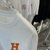 6931a28eccd8ab3d7af96a45 Hermes 2025 Spring-Summer New Short Sleeve T-Shirt with Hand-Customized Logo on Chest, Pure Cotton Fabric with Gold Thread Embroidery, Classic Buttoned Hem and OS Drop-Shoulder Fit