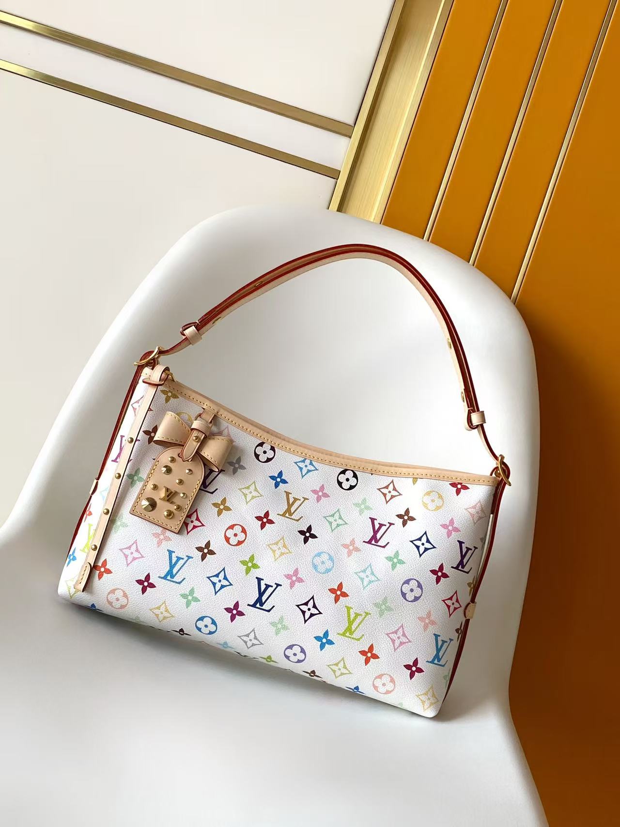 Louis Vuitton This Carryall East-West canvas handbag illuminates this classic element with a vibrant splash of color.