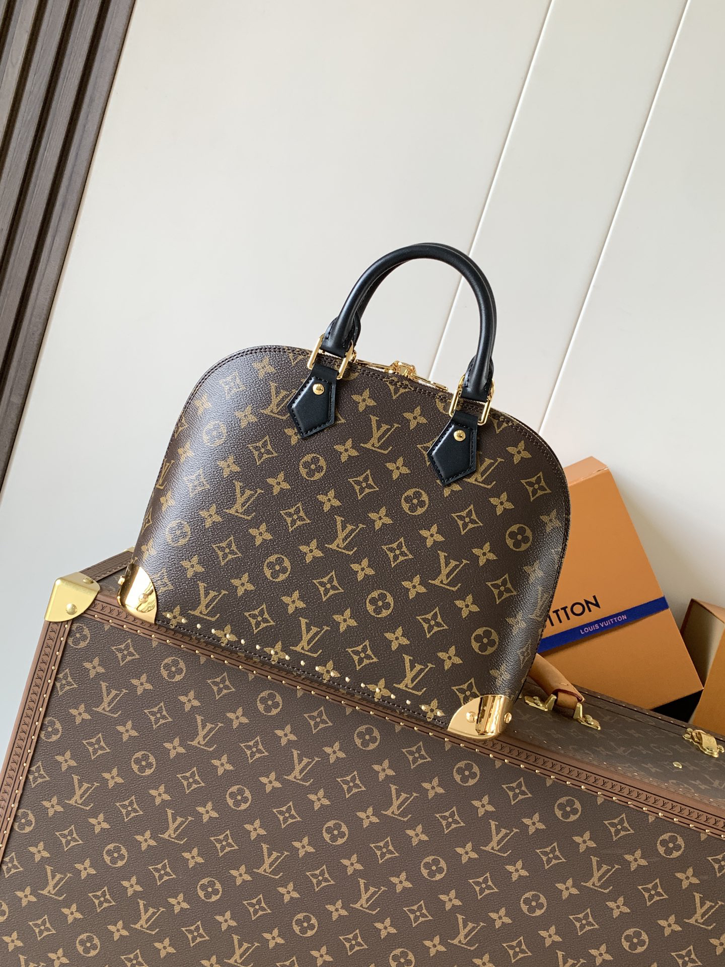 2 Louis Vuitton The Trunk collection welcomes a contemporary new iteration of the Alma Small handbag, paying homage to the brand's travel heritage with exquisite metal hardware.