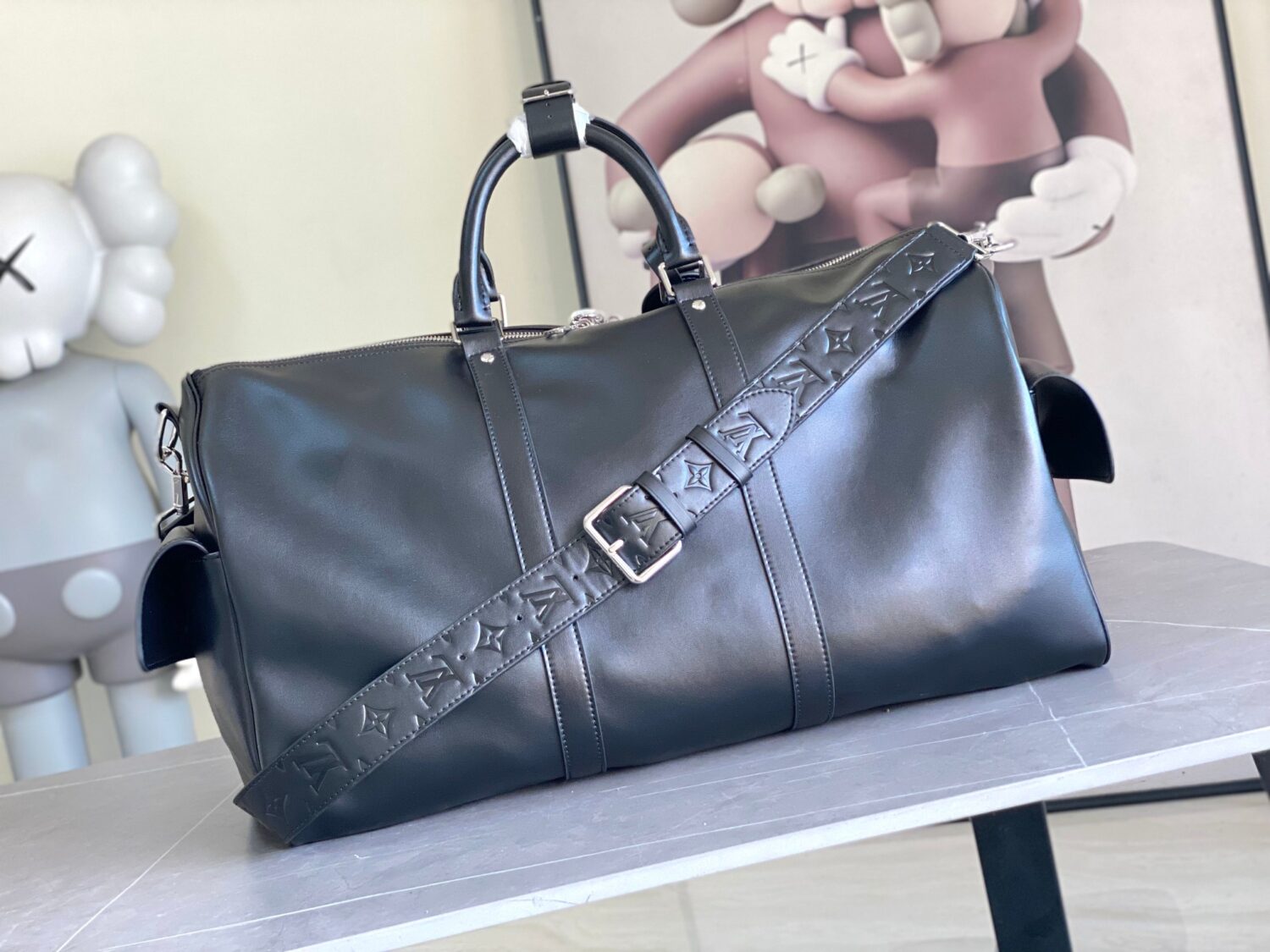 Louis Vuitton M13992 This Keepall Bandoulière 50 travel bag features a Monogram pattern on its canvas surface.